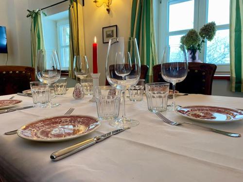 a table with wine glasses and plates on it at Urlaub mit Hund im Ferienhaus am Wingster Wald in Wingst