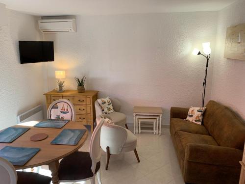 un salon avec un canapé et une table dans l'établissement Appartement RDC très grande terrasse proche mer et centre ville, à Cavalaire-sur-Mer