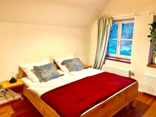 a bedroom with a large bed with a red blanket at Urlaub mit Hund im Ferienhaus am Wingster Wald in Wingst
