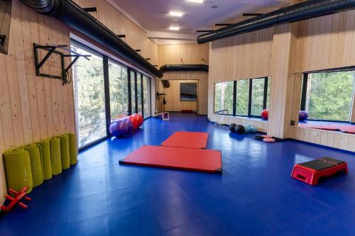 a gym with a blue floor and red mats at Spa & Wellness Hotel Fitak**** in Liptovský Ján