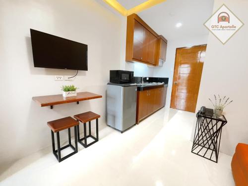 a living room with a television and a kitchen at GTC Apartelle in Tacloban