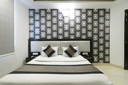 FabHotel Airport Zone Olive في نيودلهي: غرفة نوم مع سرير بجدار نمط