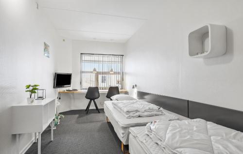 Habitación hospitalaria con 2 camas y escritorio en 2 Bedroom Nice Apartment In Fan, en Fanø