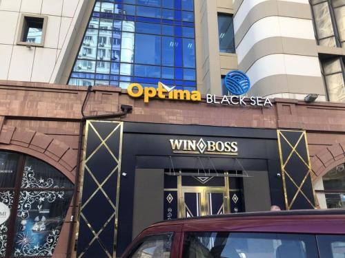 a building with a sign on the front of a store at Optima Odesa in Odesa