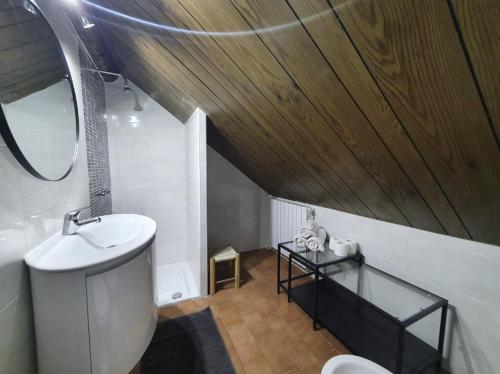 La salle de bains est pourvue d'un lavabo et d'un miroir. dans l'établissement Typical mountain mansarda close to Fiera Rho Milano MIND, à Pero