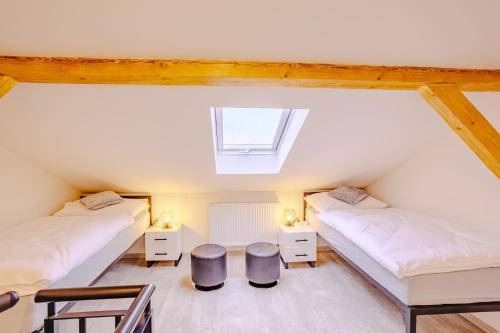 a attic bedroom with two beds and a window at Rezidence Petra Voka in Třeboň