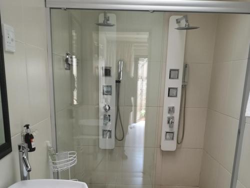 a glass shower in a bathroom with a toilet at Lilitha Hotel-Butterworth in Butterworth