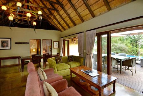 uma sala de estar com um sofá e uma mesa em Motswiri Private Safari Lodge em Madikwe Game Reserve