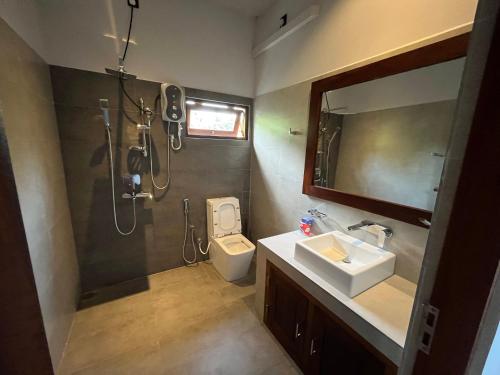 a bathroom with a shower and a toilet and a sink at Cozy Corner - Midigama in Midigama