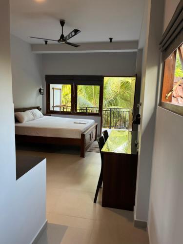 a bedroom with a bed and a view of a balcony at Cozy Corner - Midigama in Midigama