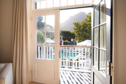 uma porta aberta para uma varanda com vista para uma piscina em One Kensington Boutique Hotel em Cidade do Cabo