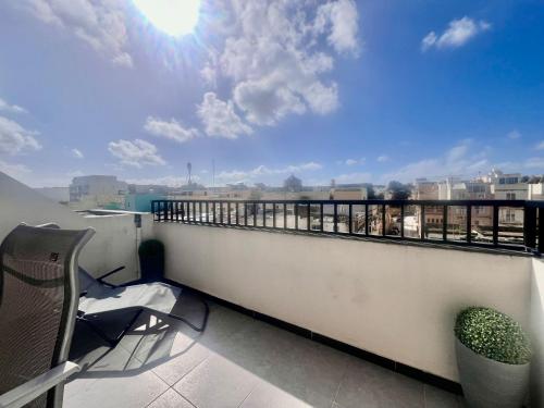 a balcony with a chair and a view of a city at 83/3-Lovely 1 Bedroom Penthouse in Birkirkara