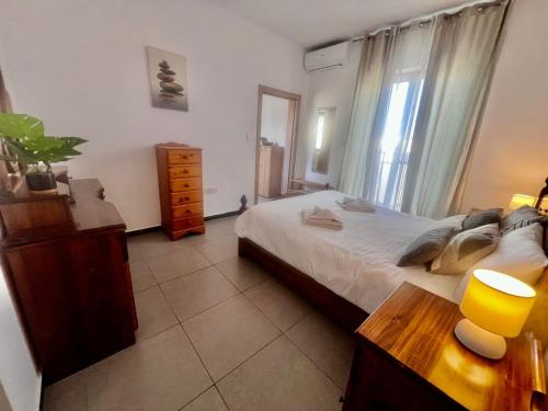 a bedroom with a bed and a dresser and a window at 83/3-Lovely 1 Bedroom Penthouse in Birkirkara