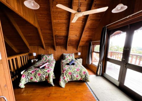 two beds in a room with a ceiling at Muri Vista Villas in Muri