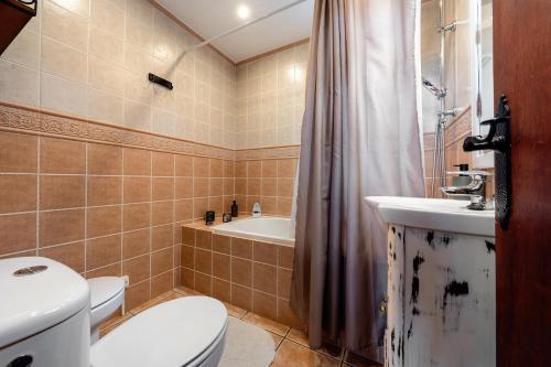een badkamer met een toilet, een wastafel en een bad bij Valle de los sueños in Canyelles