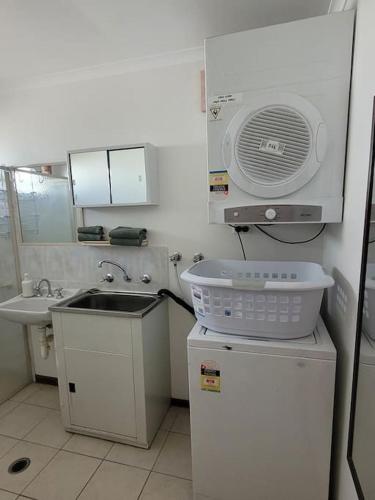 a small kitchen with a sink and a fan at The Sturt Stay in Mulwala