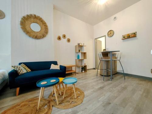 un salon avec un canapé bleu et deux tables dans l'établissement Paris I - Séjour à Auxerre, à Auxerre