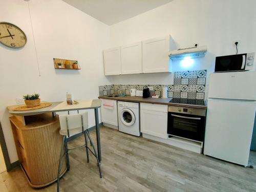 une cuisine avec un réfrigérateur blanc et une table dans l'établissement Paris I - Séjour à Auxerre, à Auxerre