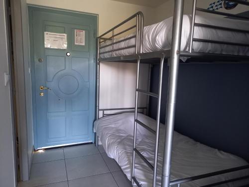 a room with two bunk beds and a blue door at La Ciotat Le Saint Estève in La Ciotat