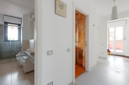 La salle de bains blanche est pourvue d'un lavabo et d'un miroir. dans l'établissement Bright Apartment with balcony and terrace, à Milan