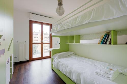 - une chambre verte et blanche avec des lits superposés dans l'établissement Bright Apartment with balcony and terrace, à Milan