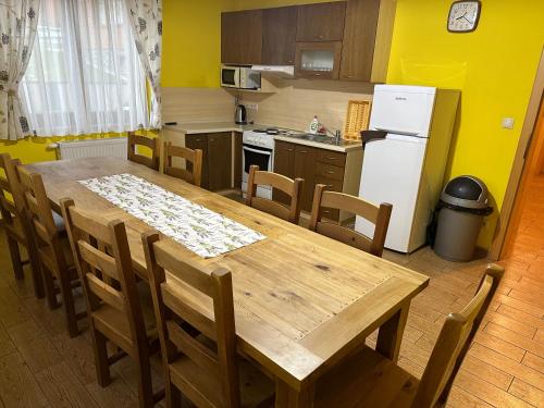 a kitchen with a wooden table and a refrigerator at Penzion Relax in Nižná
