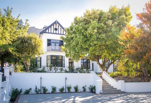 a white fence in front of a white house at One Kensington Boutique Hotel in Cape Town