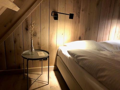 um quarto com uma cama e uma mesa com um candeeiro em Grevelingenhuys em Scharendijke