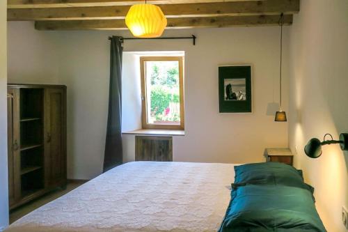 une chambre avec un lit et une fenêtre dans l'établissement gîte avec jardin - Aix les bains - Le revard, à Trévignin