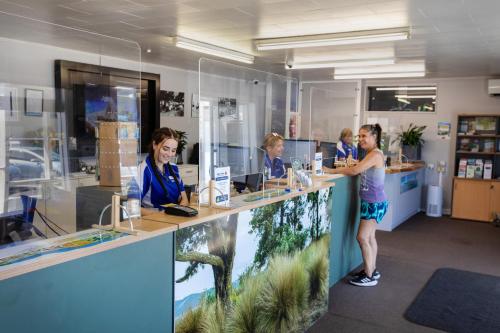 a group of people standing at a counter at Tāhuna Beach Holiday Park in Nelson
