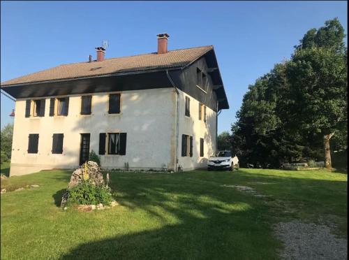 una casa blanca con un coche aparcado en el patio en Studio chaleureux au départ des sentiers et pistes de ski, en Lajoux