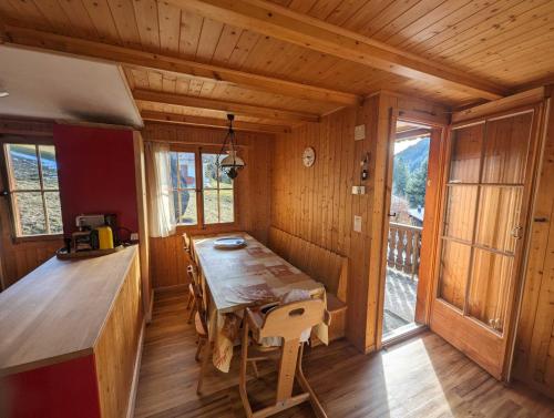 a dining room with a wooden table in a cabin at Mimöseli in Schwarzsee