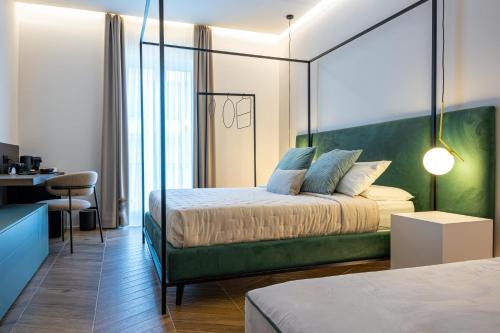 1 dormitorio con 1 cama con cabecero verde en Alcova Camere in Centro, en Agrigento