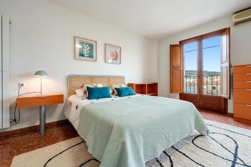 a bedroom with a bed and a table and a window at Encantador loft in Sant Sadurní dʼAnoia