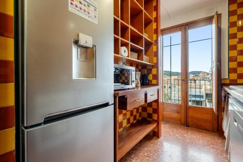 a kitchen with a stainless steel refrigerator and a window at Encantador loft in Sant Sadurní dʼAnoia