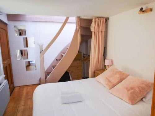 une chambre avec un lit blanc et un escalier dans l'établissement Le Lilly Rose - Mini duplex dans le cœur historique, à Strasbourg