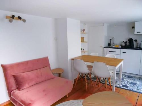 un salon avec un canapé rouge et une table dans l'établissement Le Lilly Rose - Mini duplex dans le cœur historique, à Strasbourg
