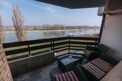 a balcony with chairs and a view of a river at Silencia in Osijek