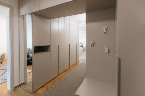 a room with white cabinets and a mirror at Silencia in Osijek