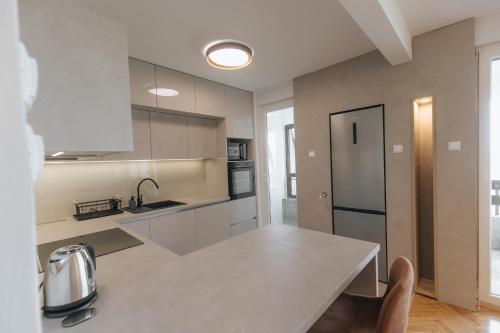 a kitchen with a table and a counter top at Silencia in Osijek