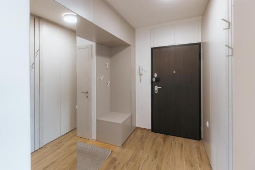 a hallway with a black door in a white room at Silencia in Osijek