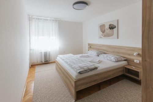 a bedroom with a bed with a wooden headboard at Silencia in Osijek
