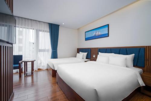 Postel nebo postele na pokoji v ubytování Ruby Star Da Nang - Central My Khe Beach