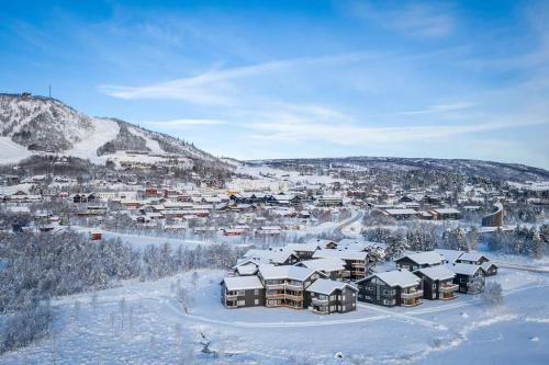 a city covered in snow with a town in the background at Sentral leilighet på Geilo in Geilo