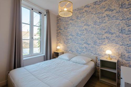 une chambre avec un grand lit et une fenêtre dans l'établissement Le Cabourgeais centre ville, à Cabourg