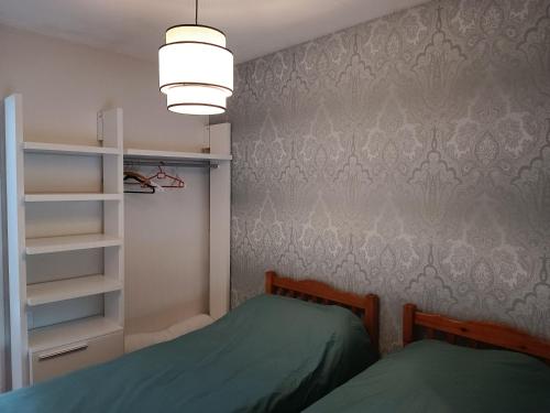 une chambre avec un lit et une étagère dans l'établissement Gîte coeur de bocéliande, à Néant-sur-Yvel