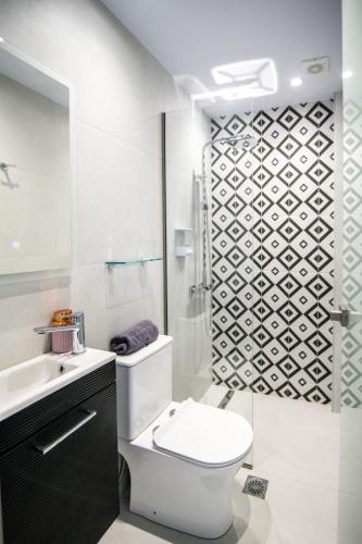 a white bathroom with a toilet and a shower at Corfu Port Studios in Mantoúkion