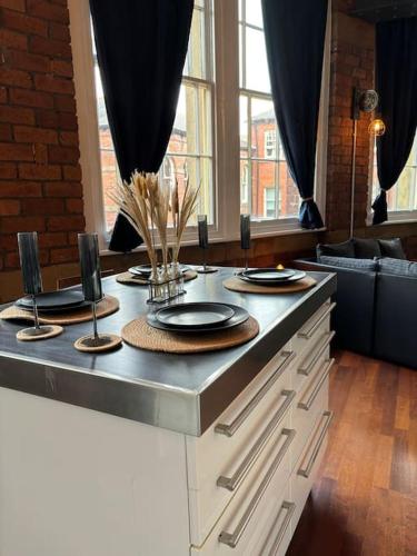 a table with plates and chargers on top of it at Unique Cathedral Quarter Victorian Apartment in Sheffield