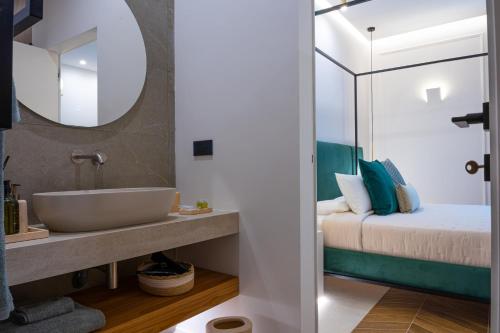 baño con lavabo y cama en Alcova Camere in Centro, en Agrigento
