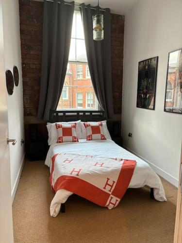 1 dormitorio con 2 camas frente a una ventana en Unique Cathedral Quarter Victorian Apartment, en Sheffield